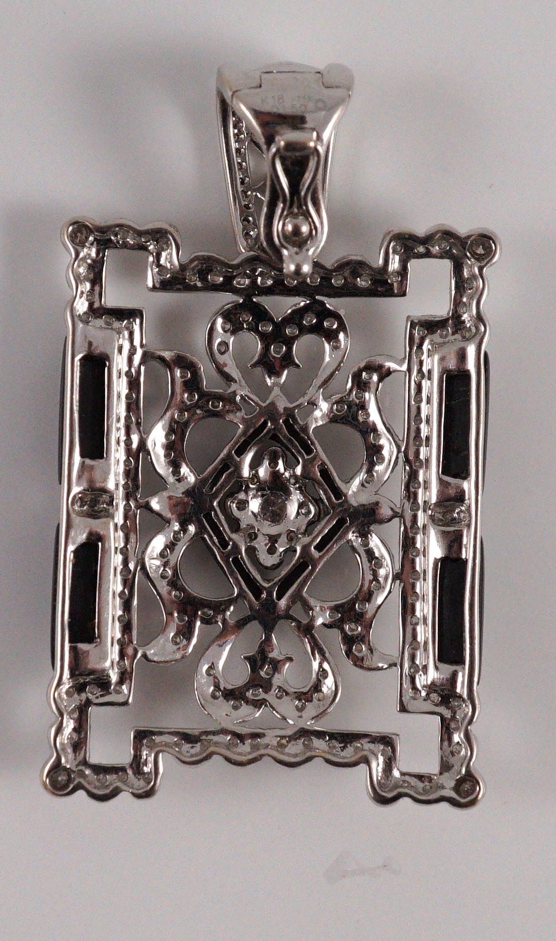 A modern 1920's style pierced 18k white gold, diamond and black onyx set rectangular pendant